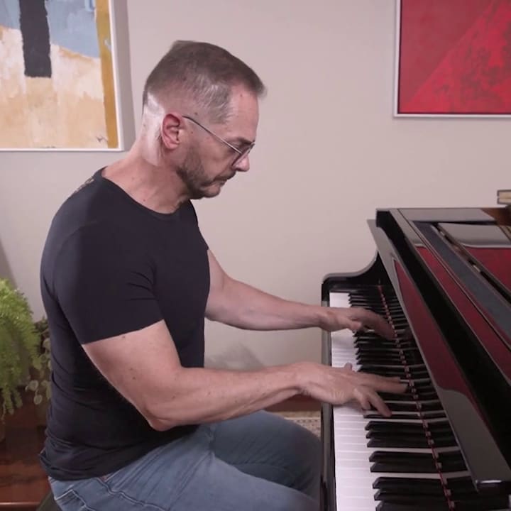O professor toca um piano de cauda em casa